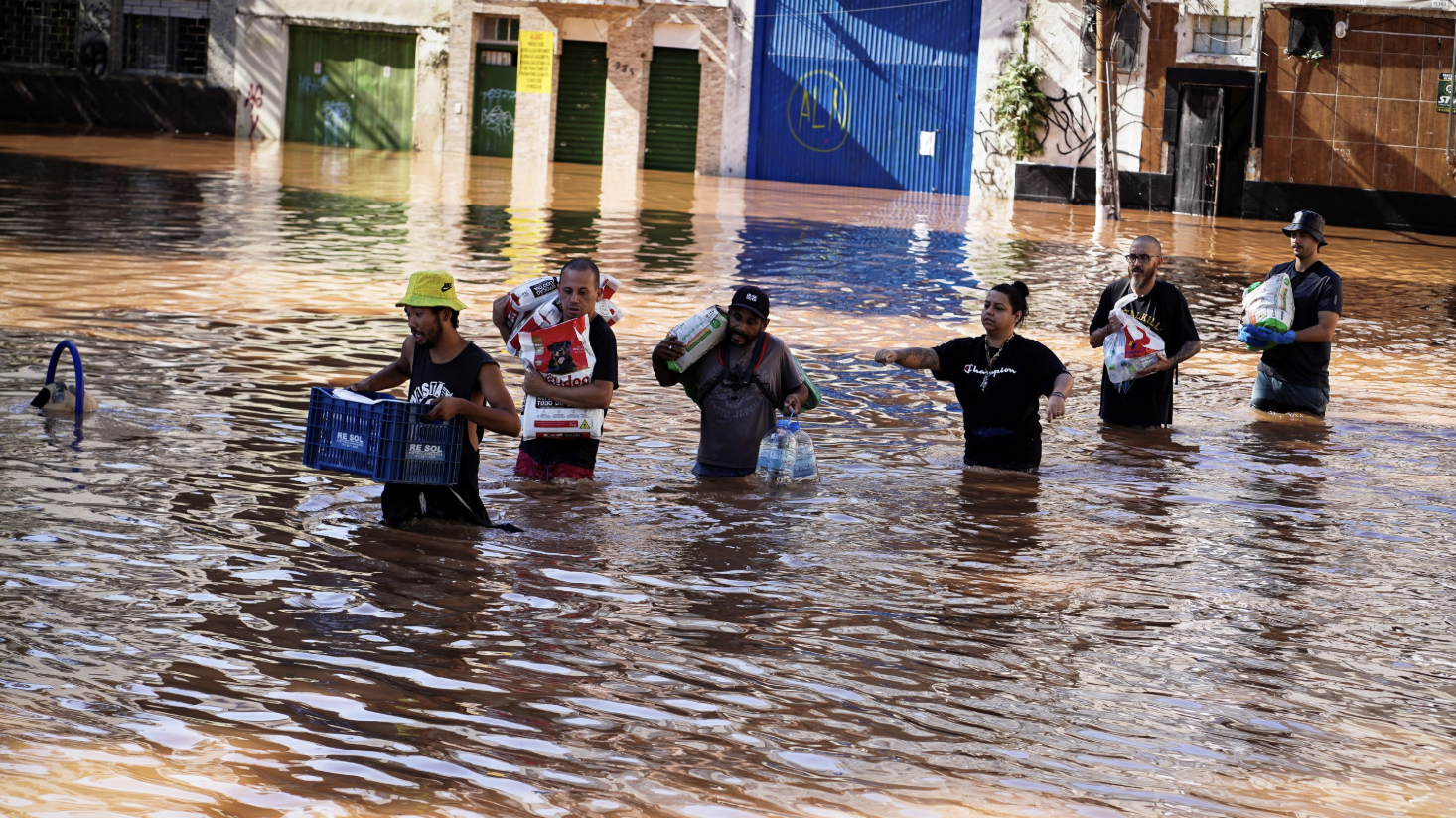 People wade through an area flooded by heavy rains in Porto Alegre, Rio Grande do Sul state, Brazil, May 6, 2024